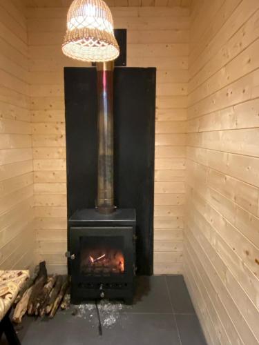 a wood stove in a room with a light at The Kiana's in Mussoorie