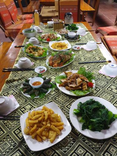 a table with many plates of food on it at Quế Homestay in Hòa Bình