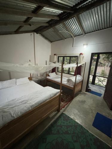 a bedroom with two bunk beds and a window at Nanu's Bardiya Homestay in Bhurkīā