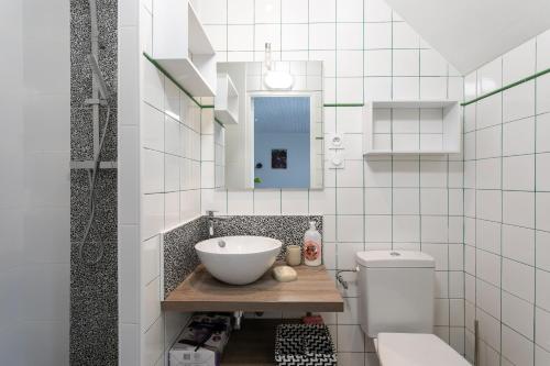 een badkamer met een wastafel en een toilet bij Maison avec piscine 20min plage in Guerlesquin