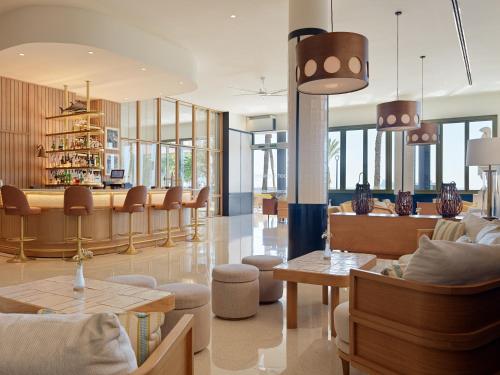 a lobby with chairs and tables and a bar at H10 Porto Poniente 4* Sup in Benidorm