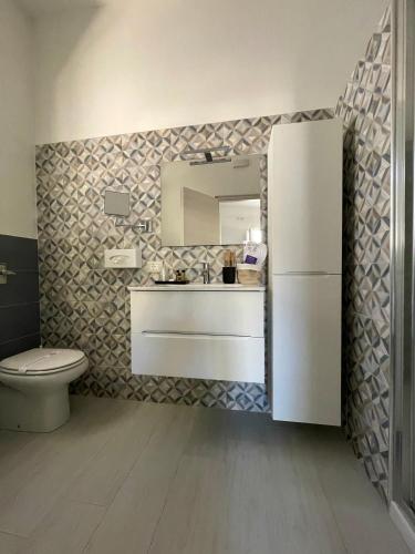 a bathroom with a sink and a white refrigerator at B&B SoleLuna in Lampedusa