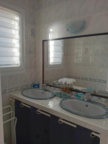 baño con 2 lavabos y espejo grande en Cocooning au Saut du Loup, en Lavergne