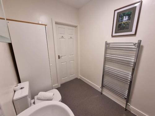 a bathroom with a toilet and a towel rack at Cromwell Apartment by Cliftonvalley Apartments in Bristol