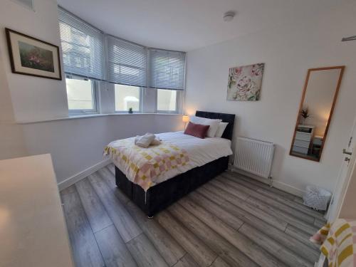 a bedroom with a bed in a room with windows at Cromwell Apartment by Cliftonvalley Apartments in Bristol