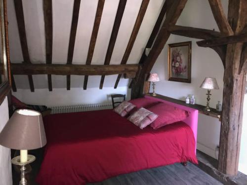 een slaapkamer met een rood bed op zolder bij Gite de la chabardiere in Mont-près-Chambord