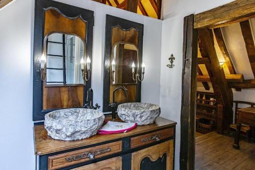een badkamer met 2 wastafels en spiegels op een aanrecht bij Gite de la chabardiere in Mont-près-Chambord