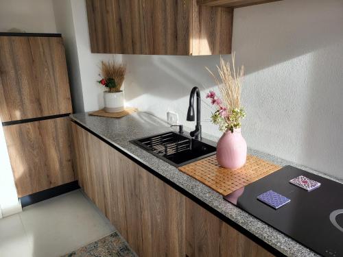a kitchen counter with a sink and a vase of flowers at Il Panorama di Ercole in Monte di Procida