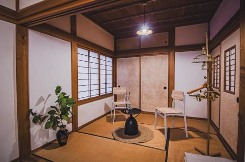 a room with two chairs and a potted plant at 【佐渡/一棟貸切】オーシャンビュー古民家SeaSideStory椿 離れ in Sado
