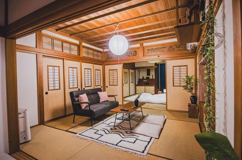 a living room with a couch and a table at 【佐渡/一棟貸切】オーシャンビュー古民家SeaSideStory椿 離れ in Sado