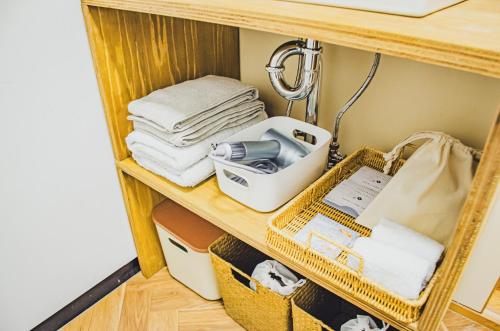 a shelf with towels and other items on it at 【佐渡/一棟貸切】オーシャンビュー古民家SeaSideStory椿 離れ in Sado