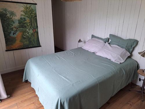 Schlafzimmer mit einem Bett mit blauer Bettwäsche und Kissen in der Unterkunft 600m bord de mer centre du val andre la maison des prés in Pléneuf-Val-André