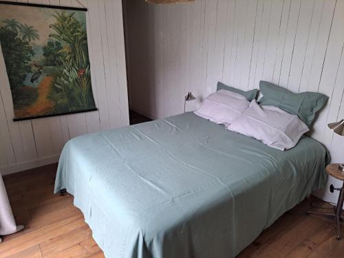 a bedroom with a bed with blue sheets and pillows at 600m bord de mer centre du val andre la maison des prés in Pléneuf-Val-André