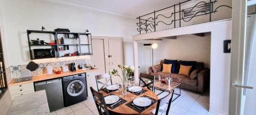 Il comprend une cuisine et un salon avec une table. dans l'établissement LE MONTMORENCY 35 Authentique Centre Historique Climatisation, à Sète