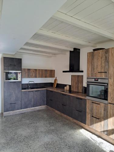 une cuisine avec des armoires en bois et un évier dans l'établissement 600m bord de mer centre du val andre la maison des prés, à Pléneuf-Val-André