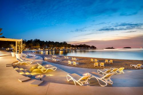 a group of chairs and tables on a beach at Maistra Camping Valkanela Pitches in Funtana