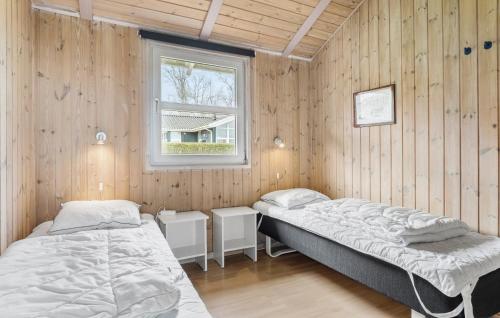 SønderbyにあるAwesome Home In Juelsminde With 4 Bedrooms, Sauna And Wifiのベッド2台 木製の壁の部屋