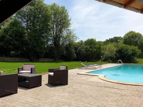 une piscine avec des chaises longues et une piscine dans l'établissement Le Chant des Ifs, à Bio