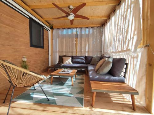 sala de estar con sofá y ventilador de techo en Mobile home Kala en Biograd na Moru