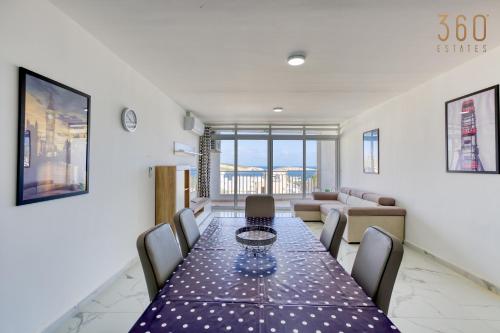 a dining room with a long table and chairs at Designer home with stunning sea views in St Pauls by 360 Estates in St Paul's Bay