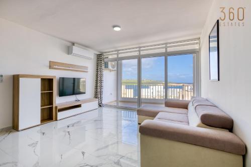 een woonkamer met een bank en een tv bij Designer home with stunning sea views in St Pauls by 360 Estates in St Paul's Bay
