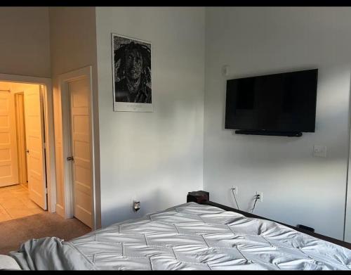 um quarto com uma cama e uma televisão de ecrã plano na parede em Deluxe! 1 Bedroom em Atlanta