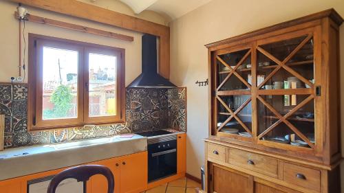 cocina con armario de madera y ventana en Apartamento El Pepito, en Granollers