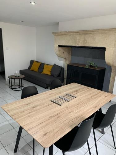 - une table en bois avec des chaises et un canapé dans l'établissement Maison proche lac de Madine, à Buxières-sous-les-Côtes