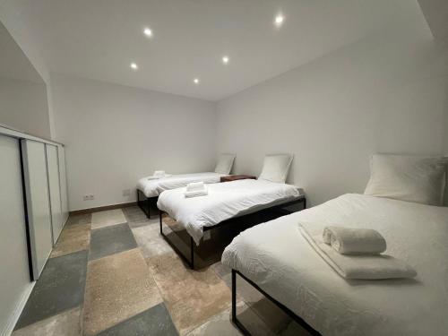 2 łóżka w małym pokoju z białymi ścianami w obiekcie Entre Mer et Vignes Perpignan w Perpignanie