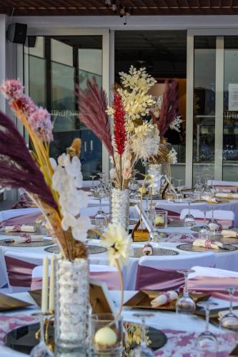 a long table with white tables with flowers in vases at Ouril Mindelo in Mindelo