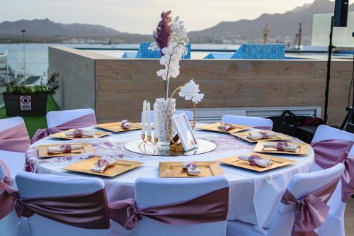 a white table with chairs and a table with flowers at Ouril Mindelo in Mindelo