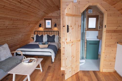 a bedroom with a bed in a wooden cabin at Glamping Pod 3 Harmony in Scarborough