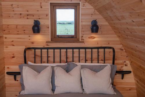 a bedroom with a bed with pillows and a window at Glamping Pod 2 Presence in Scarborough