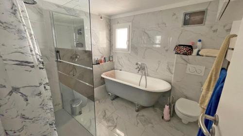 une salle de bain avec une baignoire, des toilettes et une douche dans l'établissement Hameau de Guerrevieille, à Grimaud