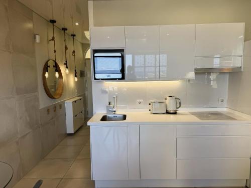a kitchen with white cabinets and a sink at Costa Adeje Orlando Tenerife Sea View - Pool - AC in Adeje