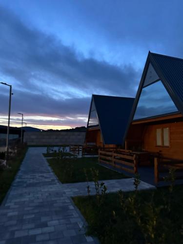 uma cabana com um telhado azul ao anoitecer em Bungalow Damiano's em Mrkonjić Grad