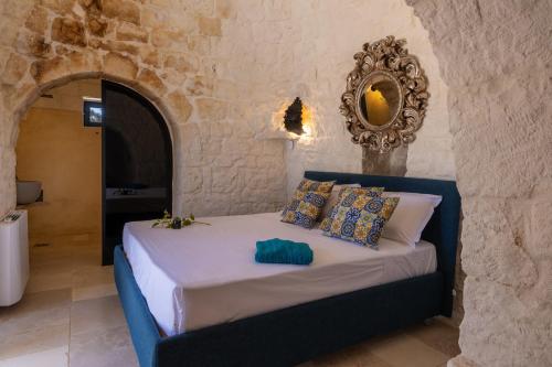a bedroom with a bed in a stone wall at Trullo con vista mare e piscina riscaldata in Carovigno