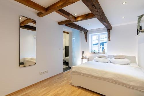 Schlafzimmer mit einem weißen Bett und einem Spiegel in der Unterkunft Fachwerk Boutique-Hotel 4 in Hattingen
