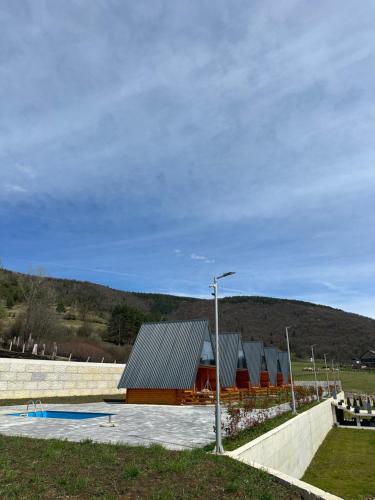 un edificio in un campo con un lampione di Bungalow Damiano's a Mrkonjić Grad