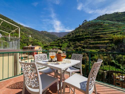 a table with wine glasses on a balcony with a view at Macaia Family Apartment with AC in Vernazza