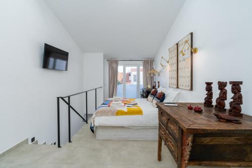 a bedroom with a bed and a desk in a room at Casa Baco- Cozy House City Center in Lagoa