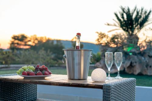 a table with a bucket of fruit and wine glasses at Vista Magica in Pastida