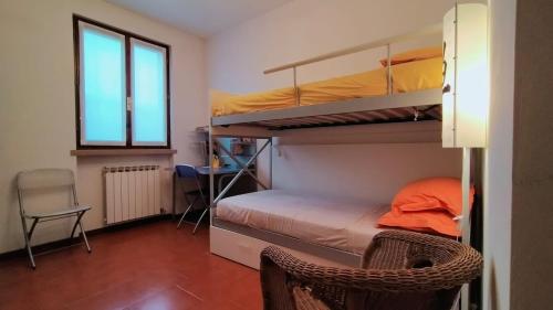 um quarto com beliches, uma secretária e uma cadeira. em Delizioso in Residence sul Garda em Polpenazze del Garda