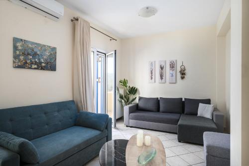 a living room with two blue couches and a table at Villa Nina with Private Plunge Pool, 5km to Corfu Town in Corfu Town