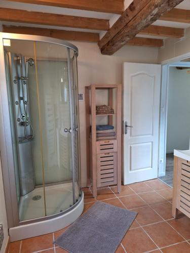 een badkamer met een douche en een glazen deur bij Maison de la Grève in Ouistreham
