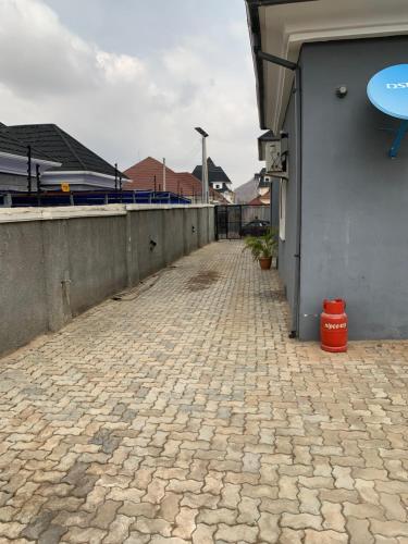 a brick walkway next to a wall and a building at Stobi Apartment in Abuja
