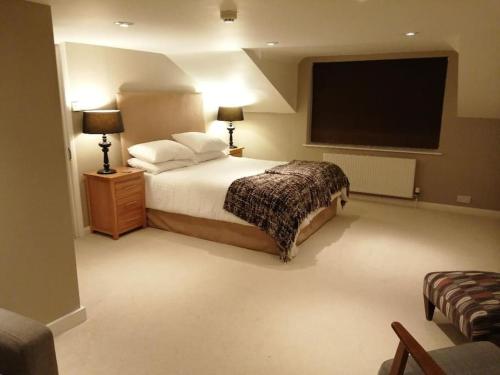 a bedroom with a bed and a flat screen tv at The Annex, The Moors House in South Zeal