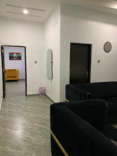 a living room with a couch and a phone on the wall at Stobi Apartment in Abuja