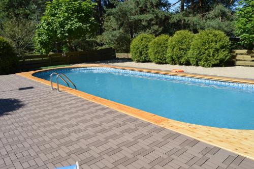 ZawadyCentrum Szkoleniowo-Wypoczynkowe Słoneczny Brzeg的带木质甲板的大型游泳池