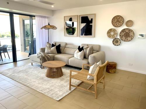 a living room with a couch and a table at Serenity Sea La Vie - 3brm Penthouse at Darwin Waterfront in Darwin